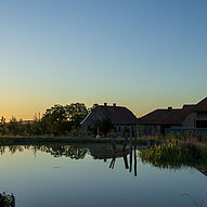 Humusland Hofteich Humusland Hofteich mit Spiegelung der Gebäude in der Abenddämmerung